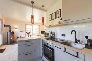 a kitchen with a sink and a stove at VITA Sonnholm - Ferienhaus mit Sauna, Ofen und Garten in Westerholz +31 photos