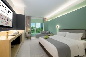 a bedroom with a large bed and a living room at Layflat Hotel in Shenzhen