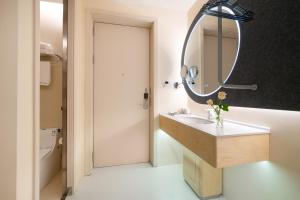 a bathroom with a sink and a mirror at Layflat Hotel in Shenzhen