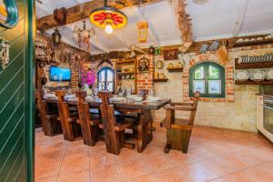 a dining room with a wooden table and chairs at Rustical Vila VERDE with traditional Tavern & Pool in Jasenice