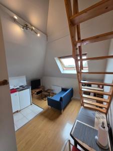 salon ze schodami i niebieską kanapą w obiekcie LE STUPLEX w Troyes
