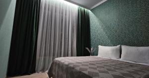 a bedroom with a bed and a green wall at Arevot Ojakh in Areni