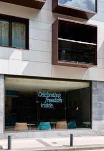 a store window with a sign that reads celebrating precision inside at Axel Hotel San Sebastián - Adults Only in Donostia-San Sebastián
