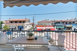 a table and chairs on a balcony with a view of a city at The Little Loft in Pefkochori
