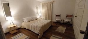 a bedroom with a bed and two chairs in it at Hostel 566 in La Serena