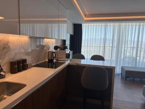 eine Küche mit einer Spüle und einer Theke mit einem Stuhl in der Unterkunft Grand Sapphire Luxury Residence in Iskele + 24 Fotos