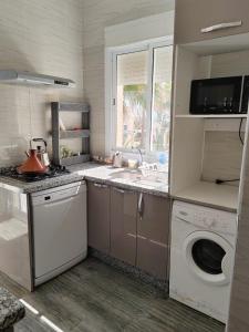 Stylish Coastal Stay with Panoramic Sea Views في طنجة: مطبخ مع حوض وغسالة ملابس +19 صورة