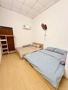 a bedroom with two beds and a fan on the wall at ChuChu House - Phuoc Hai Fishing Village in Ấp Lò Gốm
