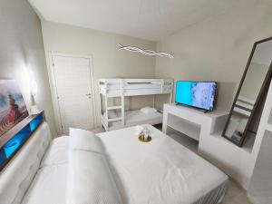 a living room with a white couch and a tv at Nido Salento Gallipoli in Gallipoli +10 photos