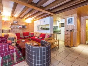 ein Wohnzimmer mit roten Möbeln und eine Küche in der Unterkunft Chalet rustique chaleureux avec cheminée à Val-d'Isère - FR-1-694-219 in Val dʼIsère