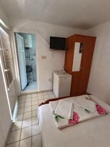 Una pequeña habitación con una cama y un baño. en Milica Soba sa kupatilom 2, en Petrovac na Moru