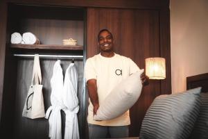 a man holding a large pillow in a hotel room at ananea Hurghada - Adults Only in Hurghada