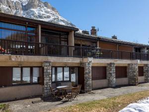 un bâtiment avec une table et des chaises devant lui dans l'établissement Charmant duplex montagnard avec grande terrasse, proche du vieux village de Val-d'Isère - FR-1-694-198, à Val dʼIsère