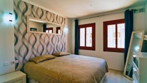 a bedroom with a bed and a wall at Winsdor Costa Adeje Apartment in Adeje +30 photos