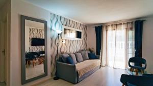 a living room with a couch and a mirror at Winsdor Costa Adeje Apartment in Adeje