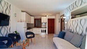 a living room with a couch and chairs and a kitchen at Winsdor Costa Adeje Apartment in Adeje