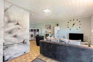 a living room with a couch and a clock on the wall at Fewo Oase Ruhrtalblick in Bestwig
