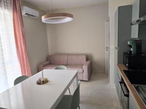a kitchen and living room with a pink couch at Nido Salento Gallipoli in Gallipoli