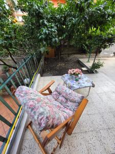 a chair and a table with flowers on a patio at Elisabeth House in Giardini Naxos