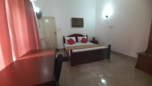 a small bedroom with a bed with red pillows at The Garden Resort Airport Katunayaka in Katunayake +28 photos