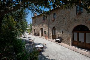 a building with chairs and a table in front of it at SARNA Residence in San Quirico dʼOrcia