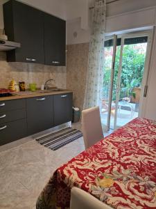 a kitchen with a bed and a kitchen with a sliding glass door at Elisabeth House in Giardini Naxos
