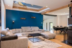 a living room with a couch and a blue wall at Villa Le Domaine Endila in Munster +18 photos