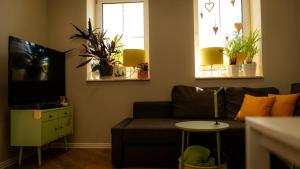 a living room with a couch and two windows at Ferienwohnung Am Eiskeller in Leuna