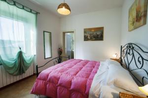 ポルト・レカナーティにあるB&B Centro Ippico Andreaのベッドルーム1室(ピンクの毛布付きの大型ベッド1台付)