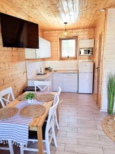 a kitchen and dining room with a table and chairs at Tropikana Domki, Apartamenty in Mielno +41 photos