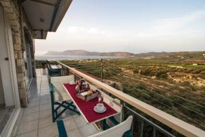 a table on a balcony with a view of the ocean at Kallergiana Studios in Kissamos