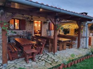 an outdoor patio with wooden tables and benches at Apartments Katičin in Poljana