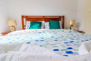 a bedroom with a large bed with blue and green pillows at Blue Mirage évasion mer & piscine privée à sidi bouzid in Sidi Bouzid