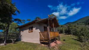 a small house with a balcony on a hill at Chalé Morada das estrelas in Aiuruoca