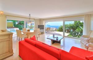 Una sala de estar con un sofá rojo y una mesa. en Villa Noyan, en Kas