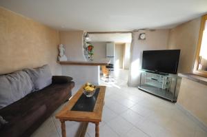 ein Wohnzimmer mit einem Sofa, einem Tisch und einem TV in der Unterkunft Lakeside Apartment in Ringgenberg