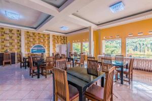 a restaurant with wooden tables and chairs and windows at Dancenter Gunung Geulis Villagee in Bogor