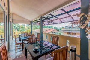 a room with a table and chairs on a balcony at Dancenter Gunung Geulis Villagee in Bogor