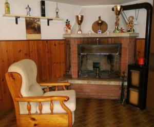 a living room with a fireplace and a chair at Casa al Pino in San Giovanni Ilarione