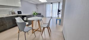 a kitchen with a table and chairs in a room at Yeosu U-Bless Terrace Ocean View in Yeosu