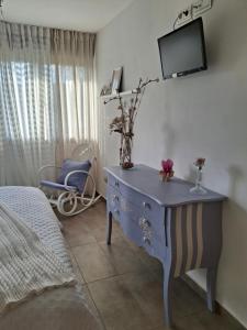 a bedroom with a blue dresser with a tv on the wall at Habitación en casa moderna con jardín in Santa Cruz de Bezana +6 photos