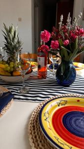 a table with plates and glasses and flowers on it at Kuća za odmor Velebit by the sea in Stinica