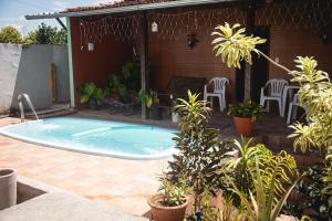 a swimming pool in a patio with chairs and plants at Cantinho da Mariazinha em Penedo in Penedo