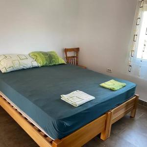 a bed in a room with a blue mattress and a window at Apartmani Vilastija in Utjeha