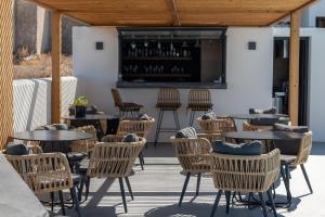 a patio with tables and chairs and a bar at North Wind Luxury Suites in Oia