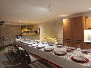 a long table with plates and wine glasses on it at Sympa Studio totalement équipé in Saint-Germain-de-Joux