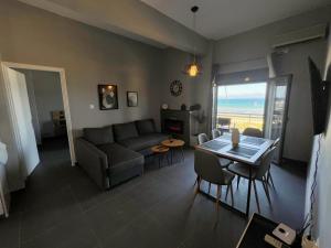 a living room with a couch and a table at Nami Sea View Near Airport Apartment in Artemida