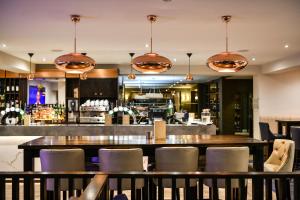 a restaurant with a table and chairs and a bar at The Nottinghamshire Hotel & Golf Club in Nottingham