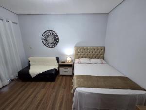 a bedroom with a bed and a table and a mirror at Loft Arara Manaus in Manaus
