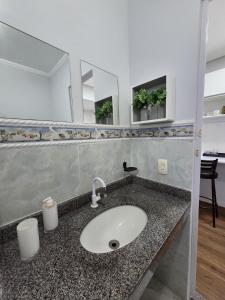 a bathroom with a sink and a mirror at Loft Arara Manaus in Manaus